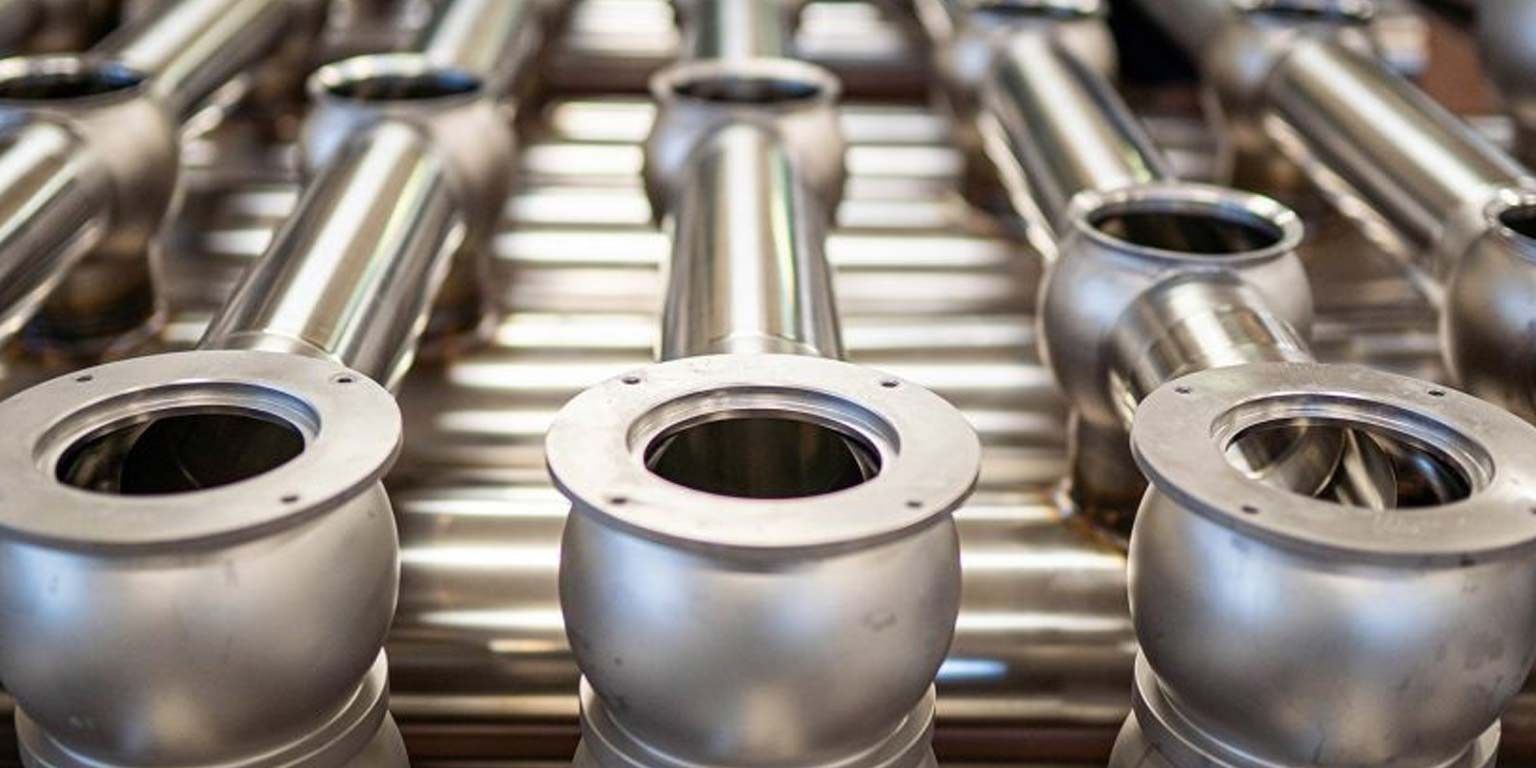 Verschiedene Edelstahlprodukte, darunter Rohre, Ventile, Beh&auml;lter und F&ouml;rdertechnik, die von P. Harloff f&uuml;r verschiedene Industrien gefertigt werden.